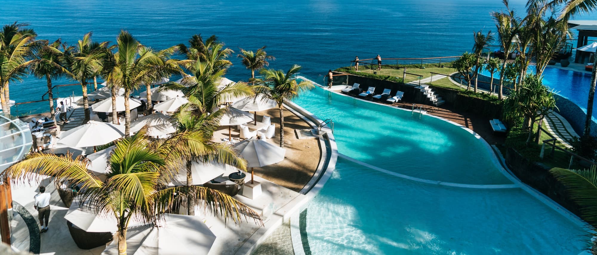 Luxury resort infinity pool overlooking the ocean — hospitality campaign visual